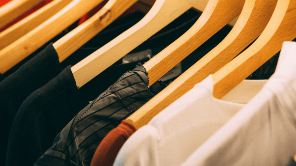 Interwaste - image of clothes on hangers in a fashion store 