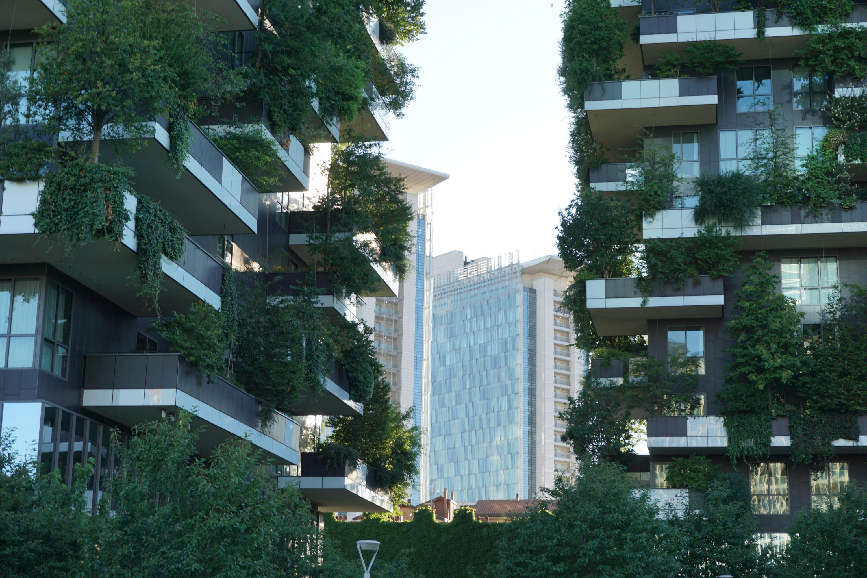 Image of green building with plants growing on its balconies